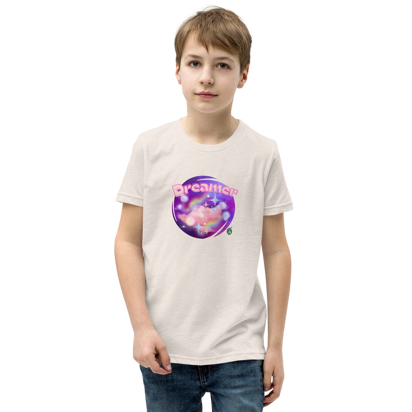 A boy standing wearing a beige kids t-shirt with the printed graphic of a galaxy and the word, Dreamer, by Wizard Prints