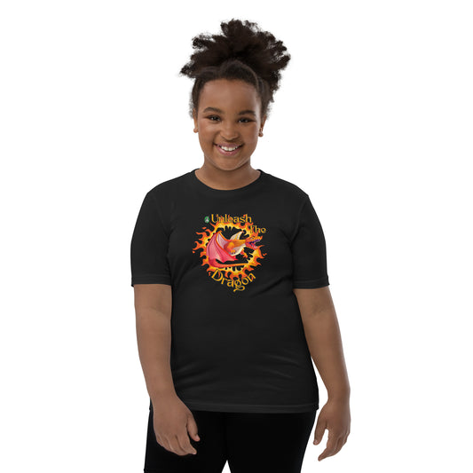A girl standing wearing a black kids t-shirt with the printed graphic of a fire-breathing dragon with the statement, Unleash the Dragon. Designed by Wizard Prints
