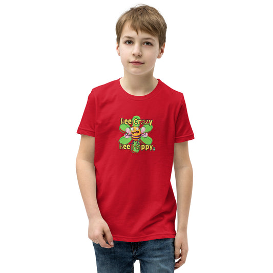 A boy standing wearing a red kids t-shirt with the printed graphic of a crazy bee and the statement, Bee Crazy Bee Happy. Designed by Wizard Prints