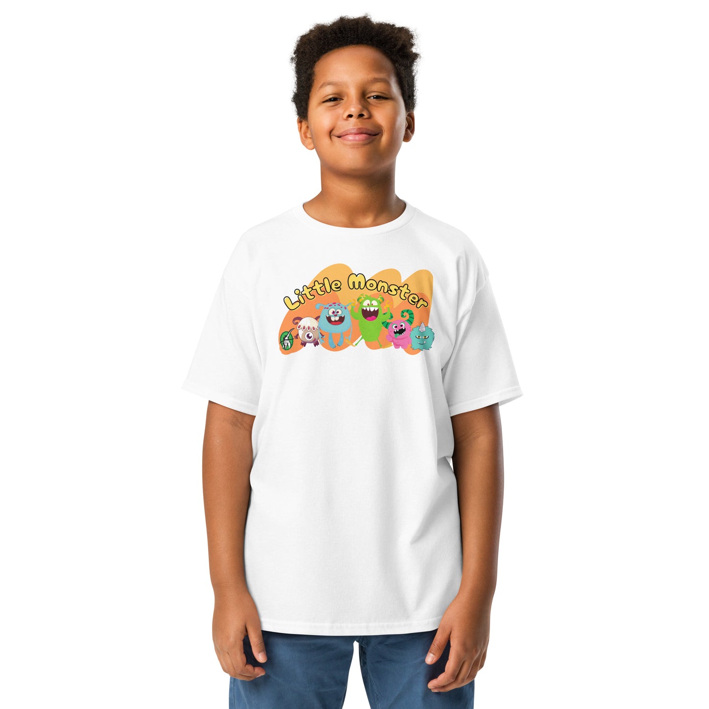 A boy standing wearing a white t-shirt with a printed graphic of colourful monsters and the words, 'Little Monster'. Designed by Wizard Prints.