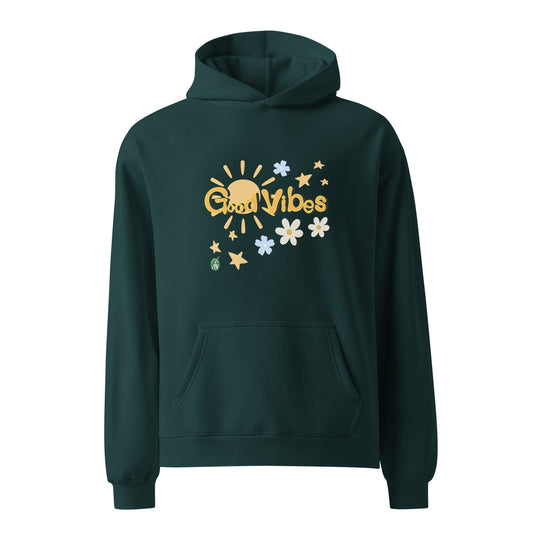 A unisex pine green hoodie by Wizard Prints featuring a printed graphic of the sun, flowers, stars and the words, 'Good Vibes'.