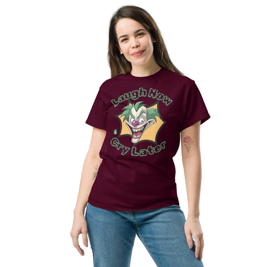 A woman standing wearing a maroon t-shirt with a printed graphic of a clown with the words, 'Laugh Now, Cry Later'. Designed by Wizard Prints.
