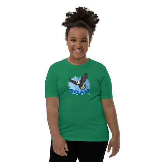A girl wearing a Wizard Prints kids t-shirt in green with a printed graphic on the front of an eagle soaring in the sky.