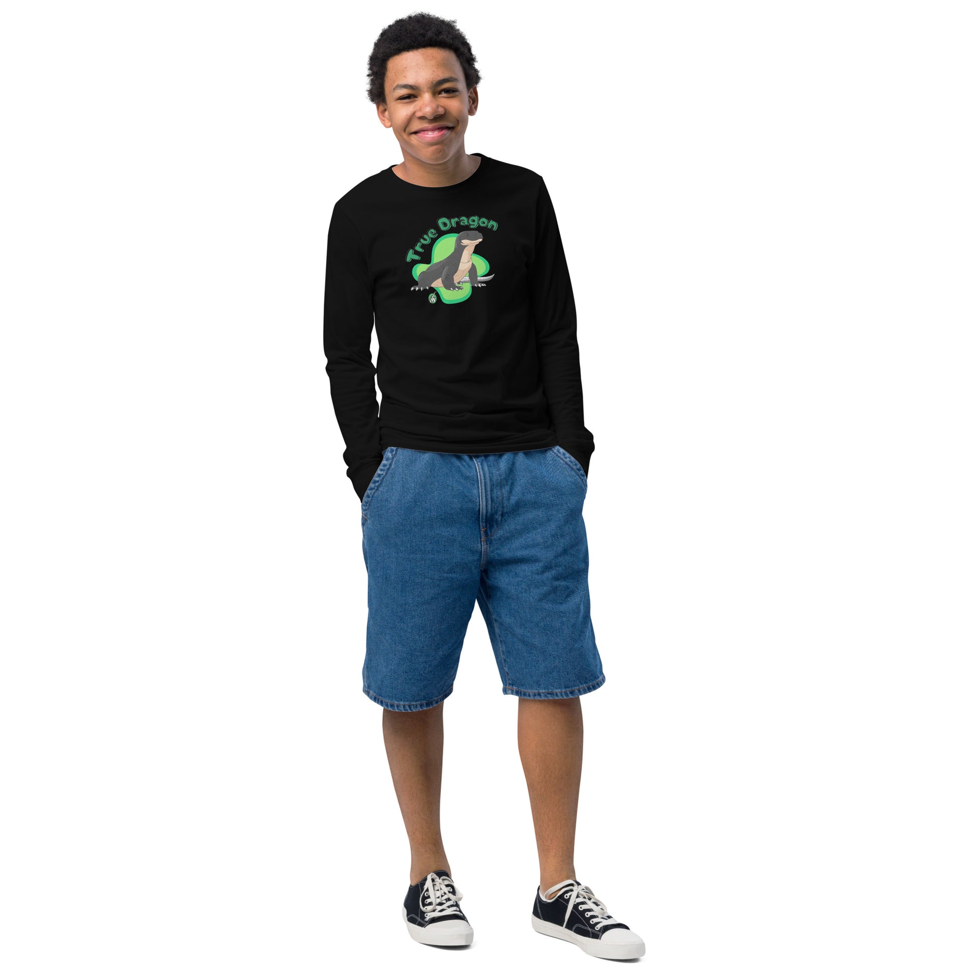 A boy standing and wearing a black long sleeve t-shirt with a printed graphic of a komodo dragon and the words, 'True Dragon'. Designed by Wizard Prints