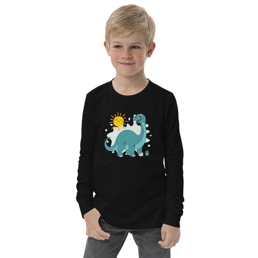A boy standing and wearing a black long sleeve t-shirt with a printed graphic of a smiling brachiosaurus and the sun. Designed by Wizard Prints