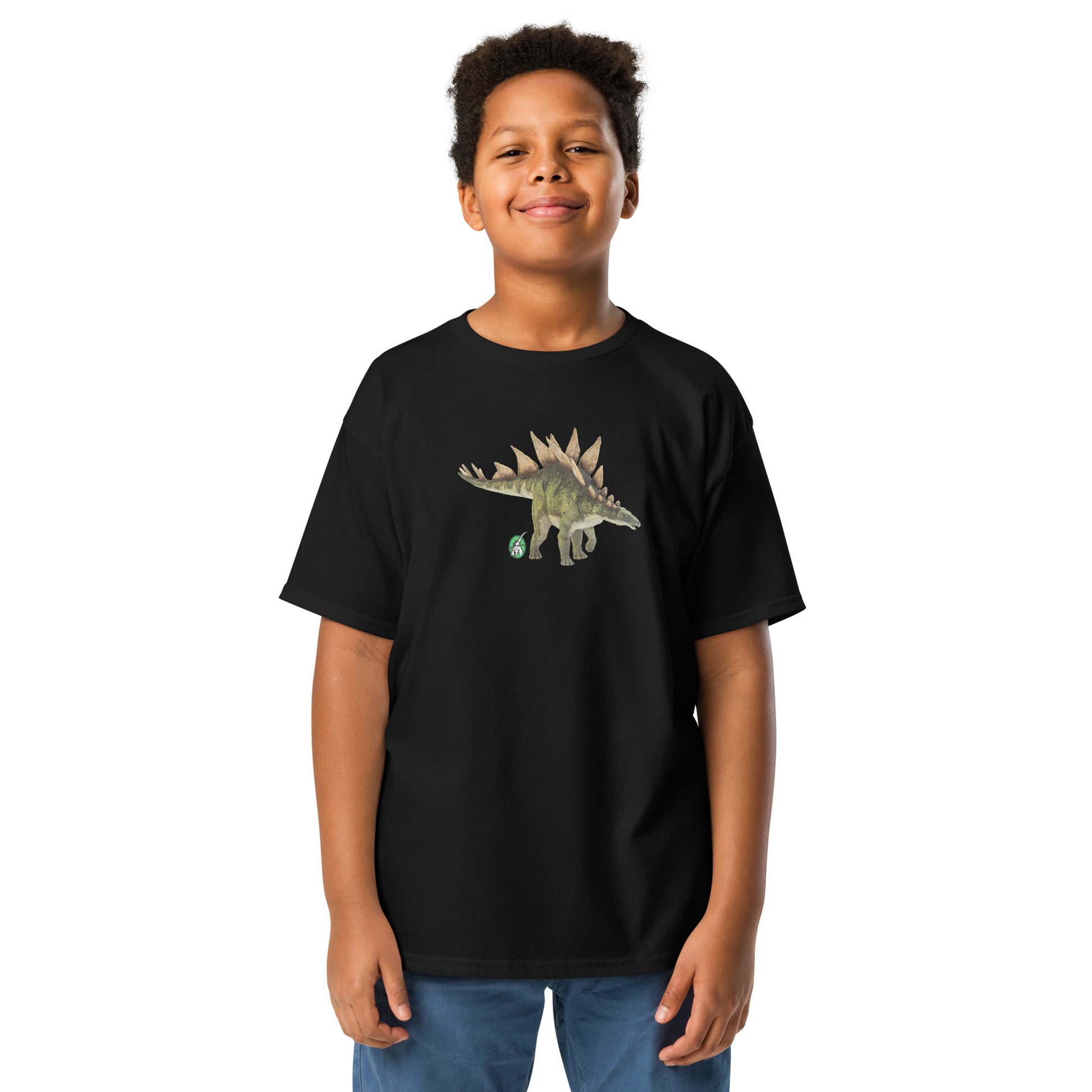 A boy standing and wearing a black t-shirt featuring a printed graphic of a life like stegosaurus, designed by Wizard Prints.