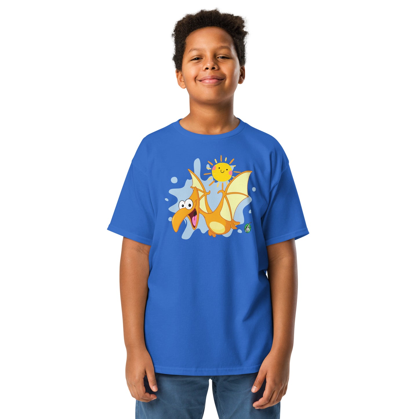 A boy standing and wearing a blue t-shirt with a printed graphic of a cartoon flying dragon and the sun. Designed by Wizard Prints.
