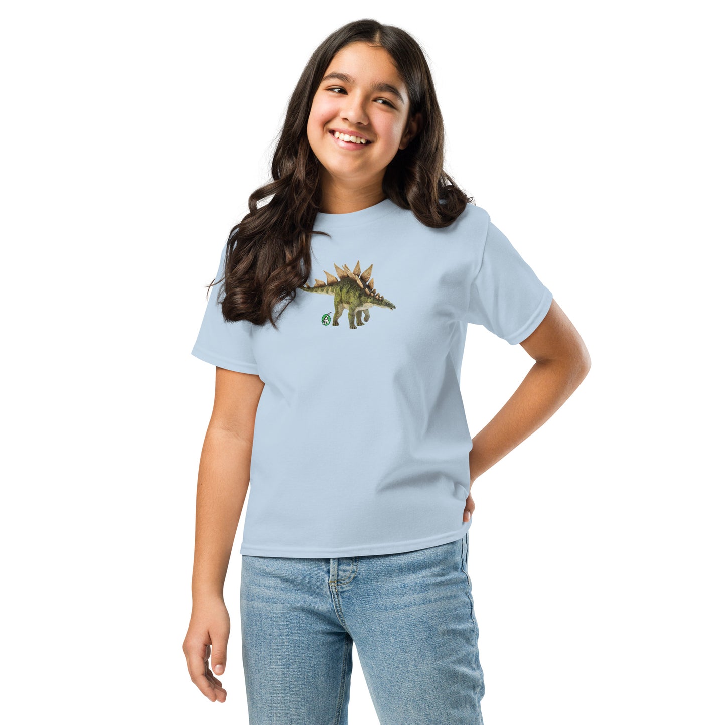 A girl standing and wearing a light blue t-shirt featuring a printed graphic of a life like stegosaurus, designed by Wizard Prints.