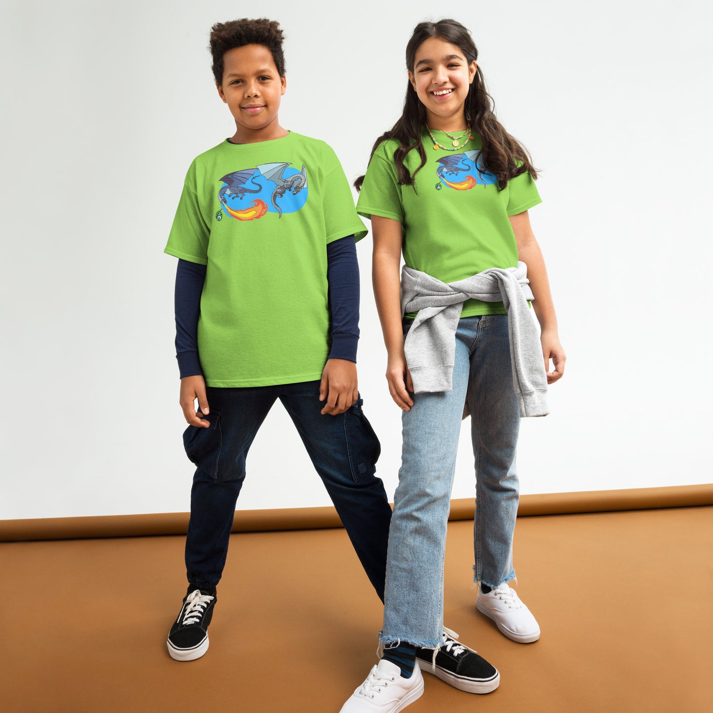 A boy and a girl standing and wearing lime green t-shirts featuring a printed graphic of two flying fiery dragons, designed by Wizard Prints.
