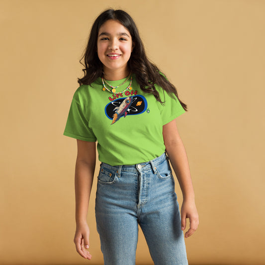 A girl standing and wearing a lime green t-shirt with a printed graphic of a rocket and the words, 'Lift Off'. Designed by Wizard Prints.