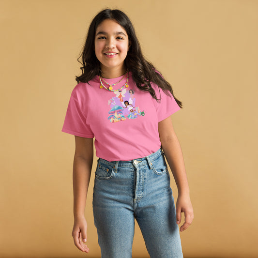 A girl standing and wearing a pink t-shirt featuring a printed graphic of fairies flying over mushrooms, designed by Wizard Prints.