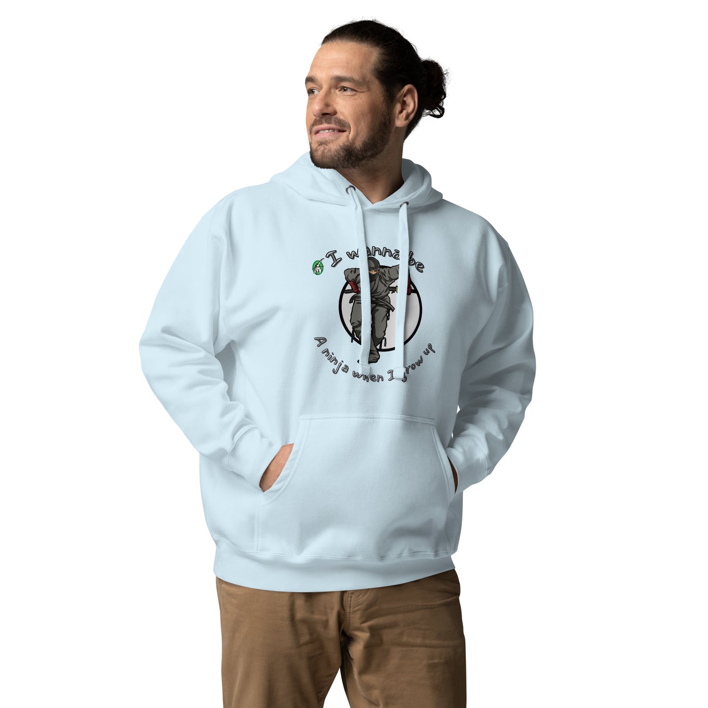 A man standing wearing a sky blue hoodie with a printed graphic of a ninja with the words, I wanna be a ninja when I grow up. Designed by Wizard Prints