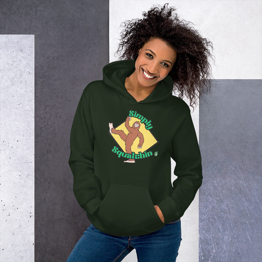 A woman standing and wearing a dark green hoodie with a printed graphic of a sasquatch with the words, Simply Squatchin. Designed by Wizard Prints.