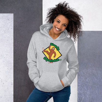 A woman standing and wearing a grey hoodie with a printed graphic of a sasquatch with the words, Simply Squatchin. Designed by Wizard Prints.