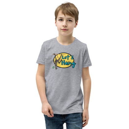 A boy standing wearing a grey graphic tee shirt with a funny graphic on the front of a monkey hanging from the tree branch saying, Let's Hang by Wizard Prints and jeans on a white background
