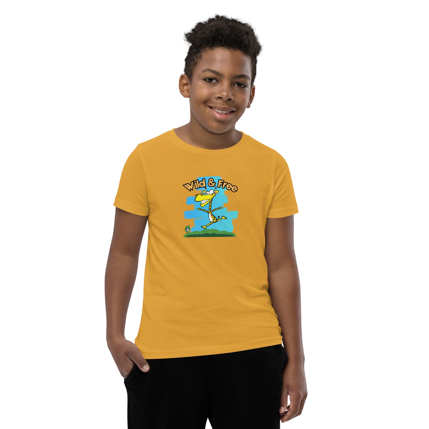 A boy standing wearing a mustard t-shirt with a funny graphic on the front of a giraffe running with the words, 'wild and free'  by Wizard Prints
