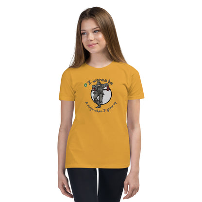A girl standing wearing a mustard kids graphic tee shirt with a ninja and the words I wanna be a ninja when I grow up, by Wizard Prints