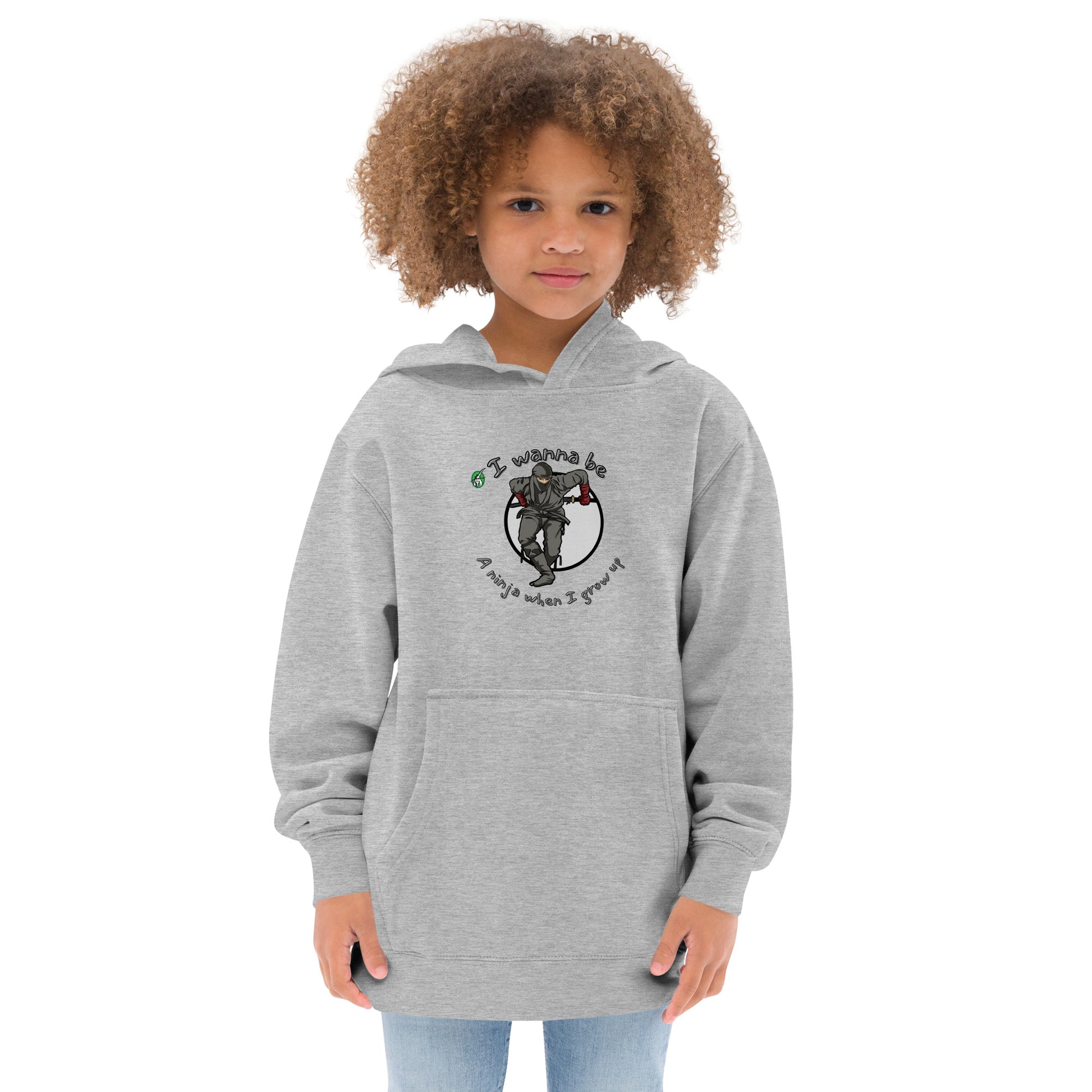 A girl standing wearing a white kids graphic hoodie with a ninja and the words I wanna be a ninja when I grow up, by Wizard Prints