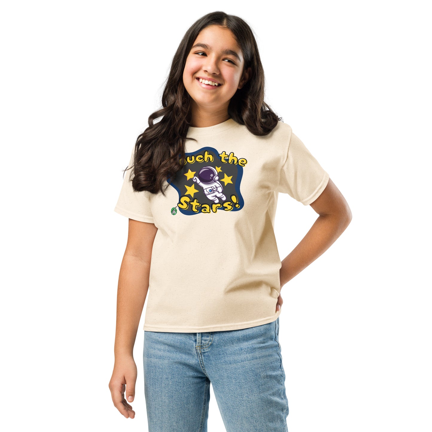 A girl standing and wearing a beige t-shirt featuring a printed graphic of a cartoon astronaut and the words, 'Touch the Stars'. Designed by Wizard Prints.