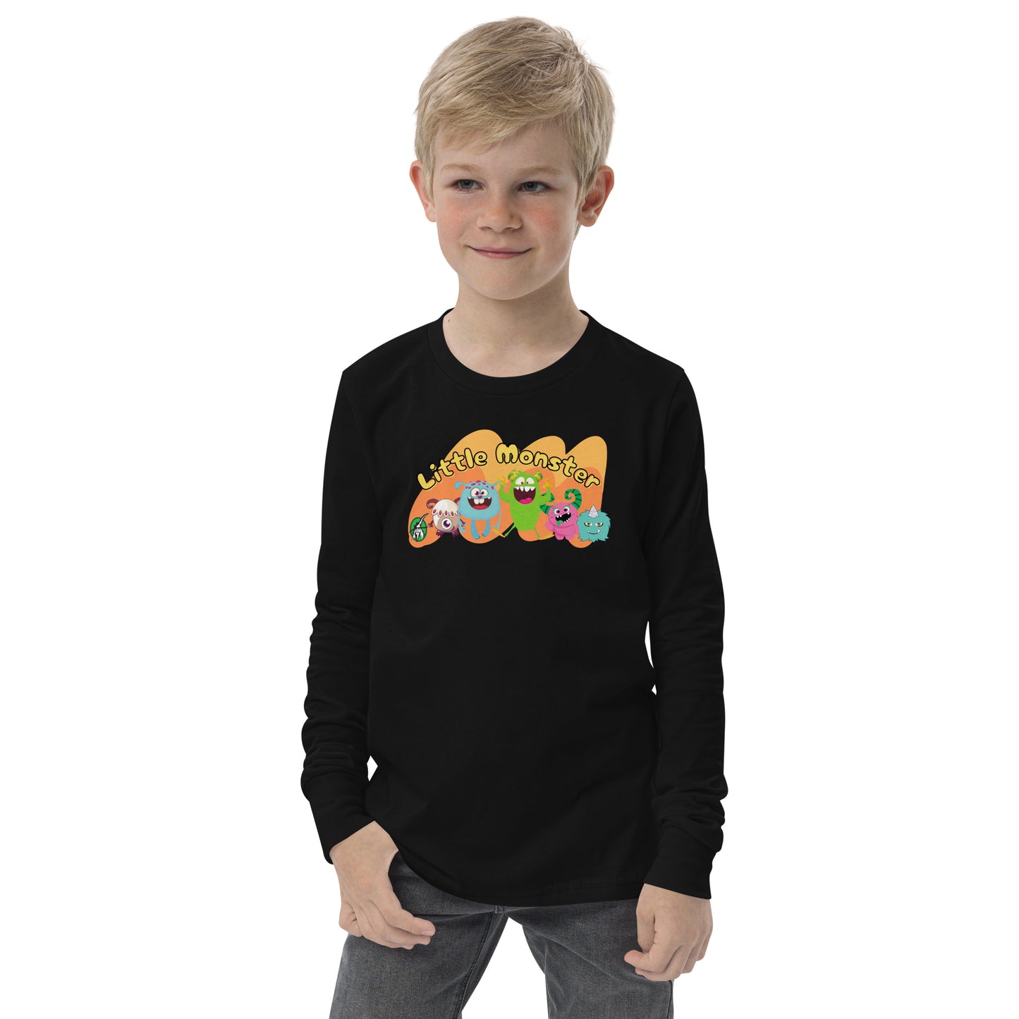 A boy standing wearing a black t-shirt with a printed graphic of colourful monsters and the words, 'Little Monster'. Designed by Wizard Prints.