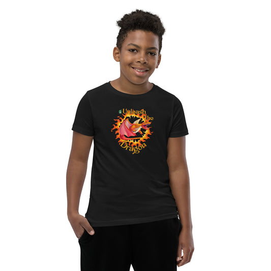  A boy standing wearing a black kids t-shirt with the printed graphic of a fire-breathing dragon with the statement, Unleash the Dragon. Designed by Wizard Prints