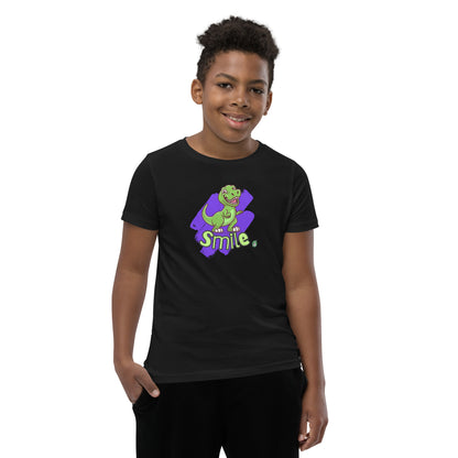  A boy standing wearing a black kids t-shirt with the printed graphic of a cartoon dinosaur and the word, Smile. Designed by Wizard Prints