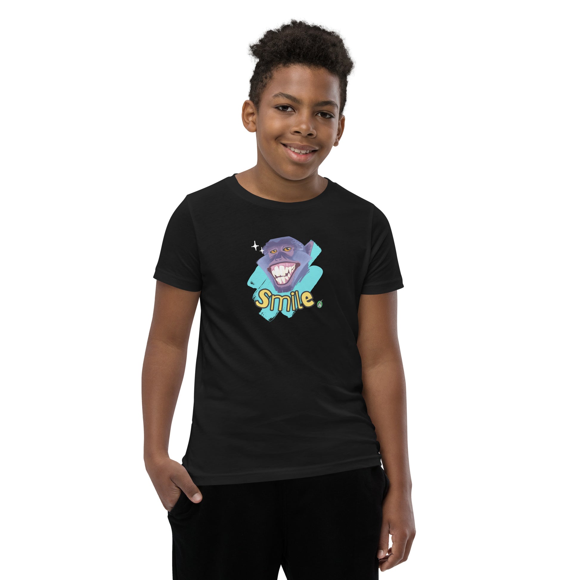  A boy standing wearing a black kids t-shirt with the printed graphic of a smiling monkey and the word, Smile. Designed by Wizard Prints