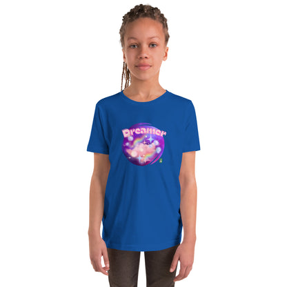  A girl standing wearing a blue kids t-shirt with the printed graphic of a galaxy and the word, Dreamer, by Wizard Prints