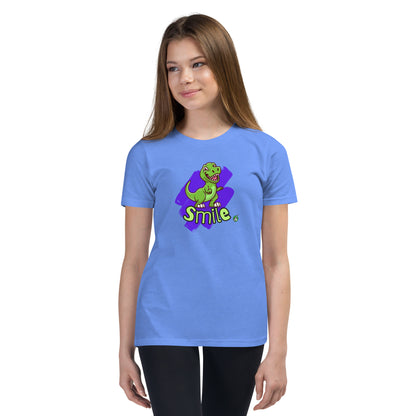 A girl standing wearing a blue kids t-shirt with the printed graphic of a cartoon dinosaur and the word, Smile. Designed by Wizard Prints