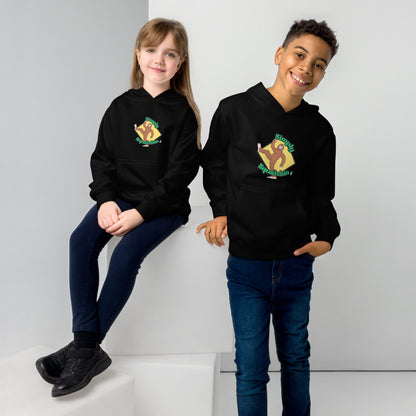 A boy standing and a girl sitting both wearing a black kids graphic hoodie with a brown sasquatch and the statement, Simply Squatchin on a yellow background, by Wizard Prints