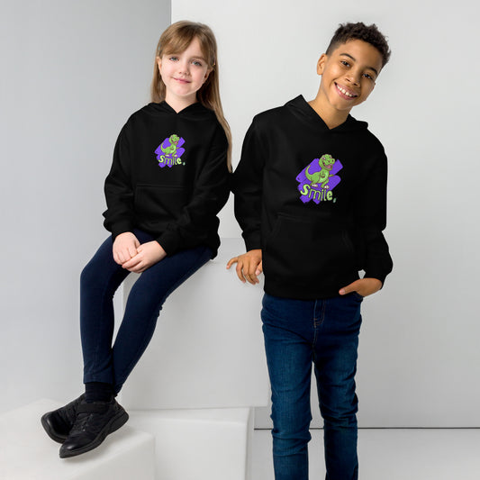 A boy standing and a girl sitting both wearing a black kids graphic hoodie with a green dinosaur and the word Smile on a purple background, by Wizard Prints