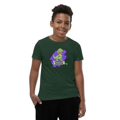  A boy standing wearing a forest green kids t-shirt with the printed graphic of a cartoon dinosaur and the word, Smile. Designed by Wizard Prints