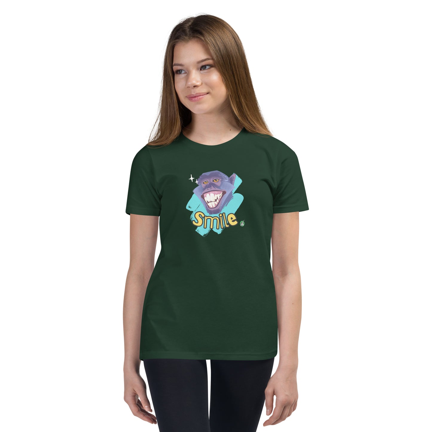  A girl standing wearing a forest green kids t-shirt with the printed graphic of a smiling monkey and the word, Smile. Designed by Wizard Prints