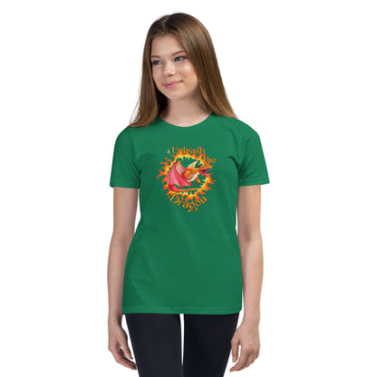  A girl standing wearing a green kids t-shirt with the printed graphic of a fire-breathing dragon with the statement, Unleash the Dragon. Designed by Wizard Prints