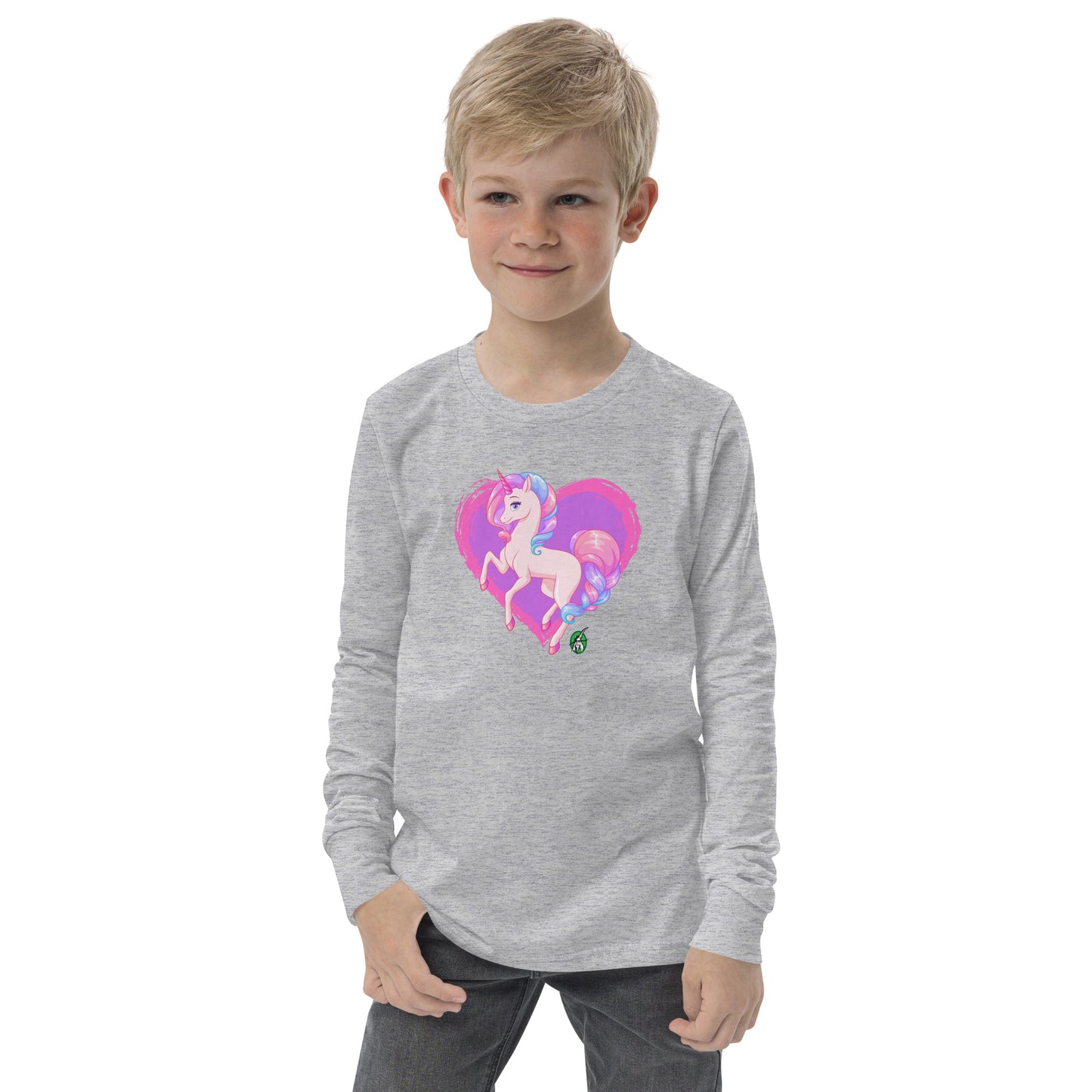 A boy standing and wearing a grey long-sleeve T-shirt featuring a printed graphic of a pink unicorn on a purple heart background, by Wizard Prints.