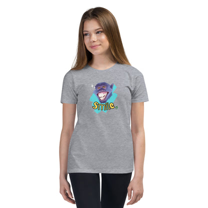  A girl standing wearing a grey kids t-shirt with the printed graphic of a smiling monkey and the word, Smile. Designed by Wizard Prints