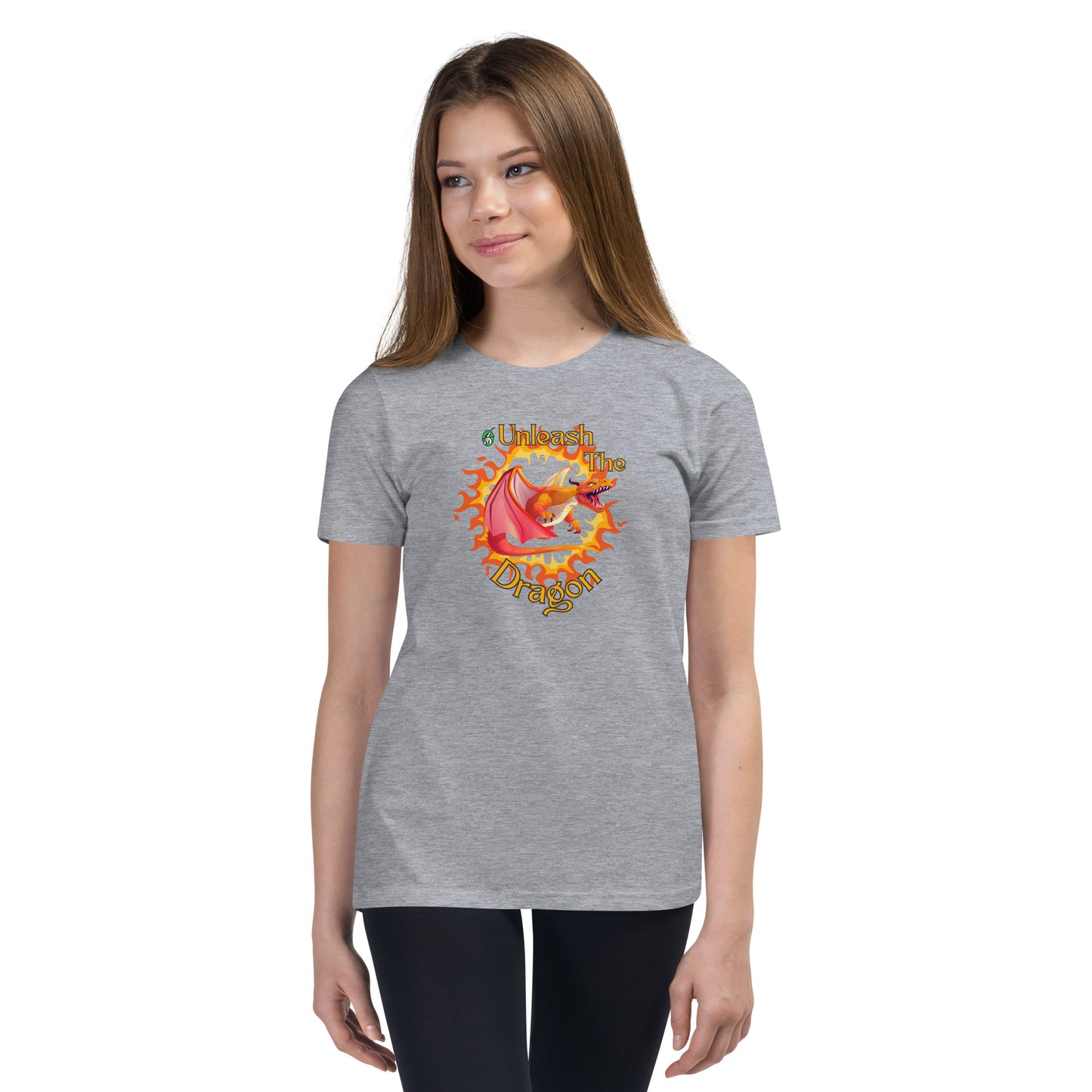  A girl standing wearing a grey kids t-shirt with the printed graphic of a fire-breathing dragon with the statement, Unleash the Dragon. Designed by Wizard Prints