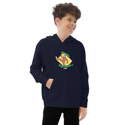 A boy standing wearing a navy blue kids graphic hoodie with a brown sasquatch and the statement, Simply Squatchin on a yellow background, by Wizard Prints