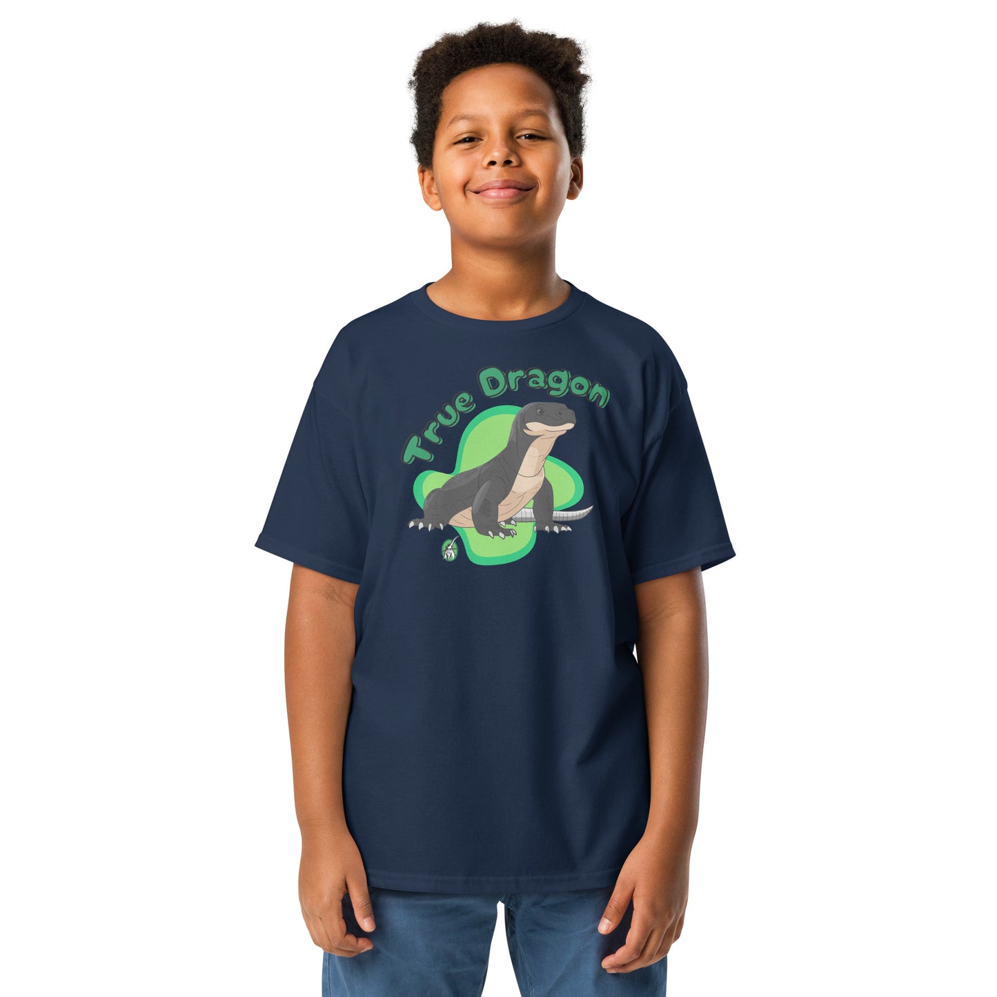 A boy standing and wearing a navy blue t-shirt featuring a printed graphic of a komodo dragon and the words, True Dragon. Designed by Wizard Prints.