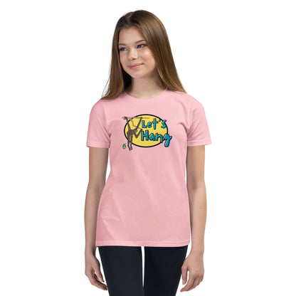 A girl standing wearing a pink graphic tee shirt with a funny graphic on the front of a monkey hanging from the tree branch saying, Let's Hang by Wizard Prints and jeans on a white background
