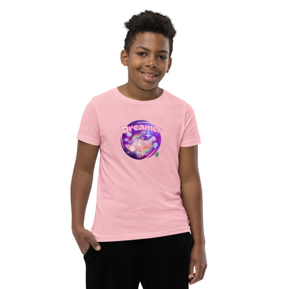  A boy standing wearing a pink kids t-shirt with the printed graphic of a galaxy and the word, Dreamer, by Wizard Prints