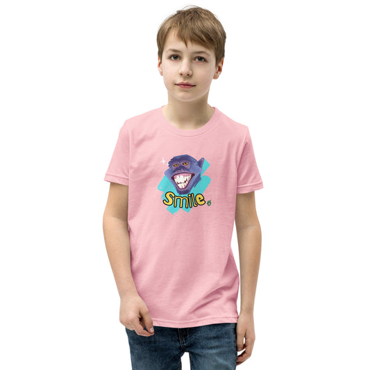  A boy standing wearing a pink kids t-shirt with the printed graphic of a smiling monkey and the word, Smile. Designed by Wizard Prints