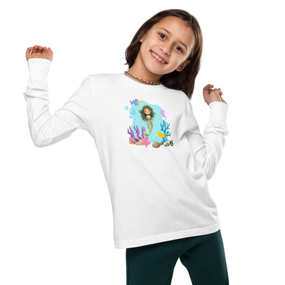 A girl standing and wearing a white long-sleeve T-shirt featuring a printed graphic of a mermaid with sea creatures and water, by Wizard Prints.
