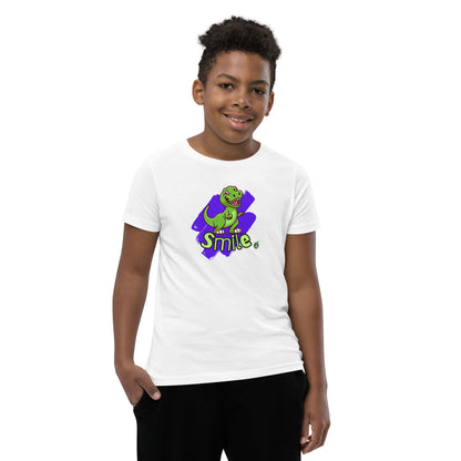  A boy standing wearing a white kids t-shirt with the printed graphic of a cartoon dinosaur and the word, Smile. Designed by Wizard Prints