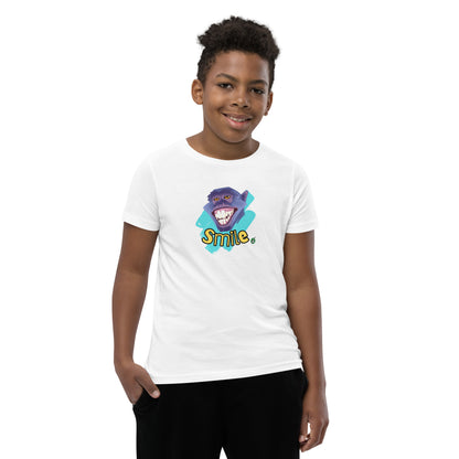  A boy standing wearing a white kids t-shirt with the printed graphic of a smiling monkey and the word, Smile. Designed by Wizard Prints