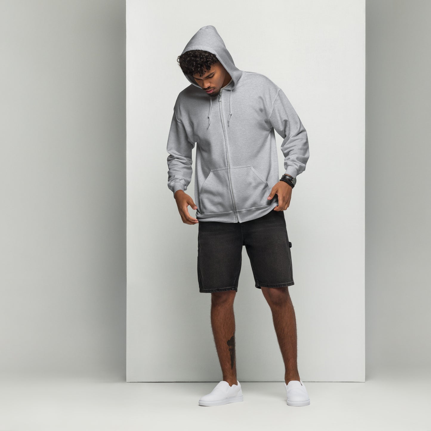 A man standing wearing a grey zip through hoodie by Wizard Prints Shop and jeans