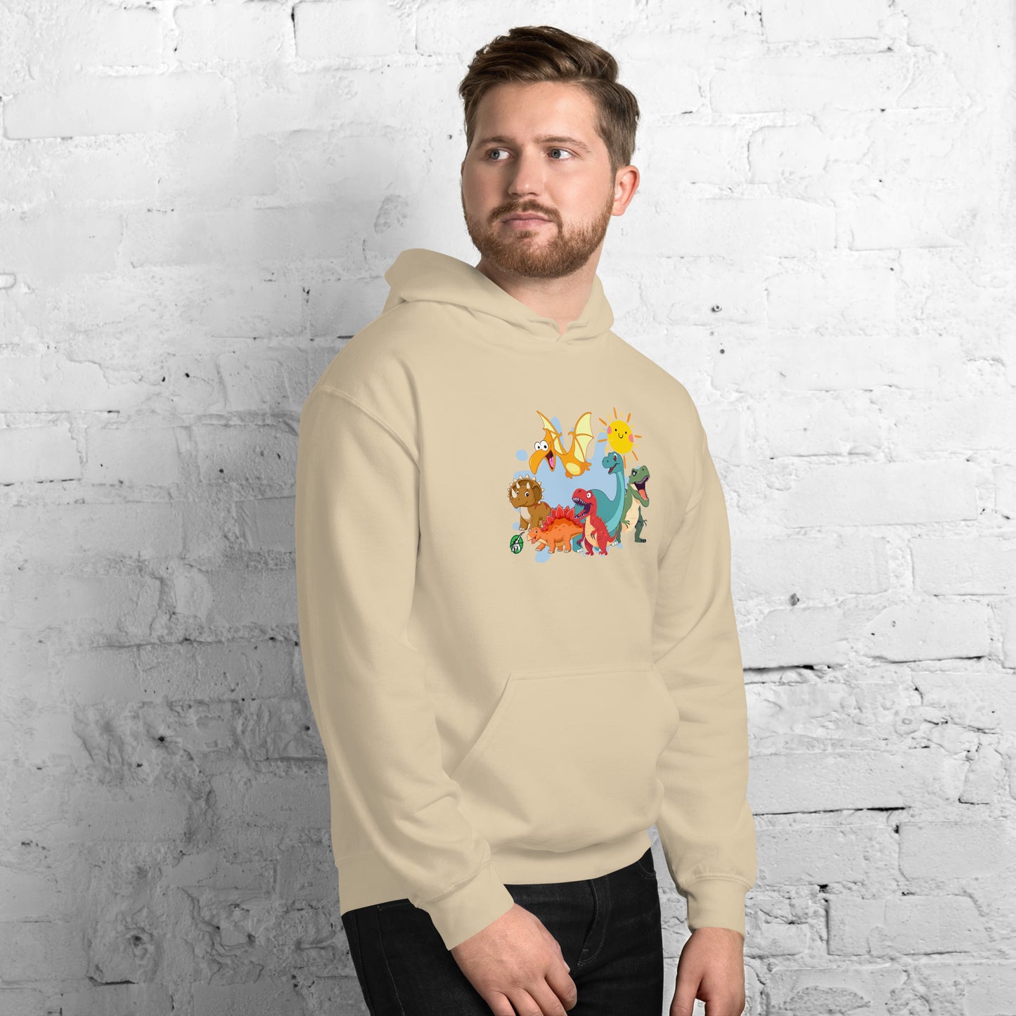 A man standing wearing a beige hoodie with a printed graphic of different colorful dinosaur types and the sun. Designed by Wizard Prints.