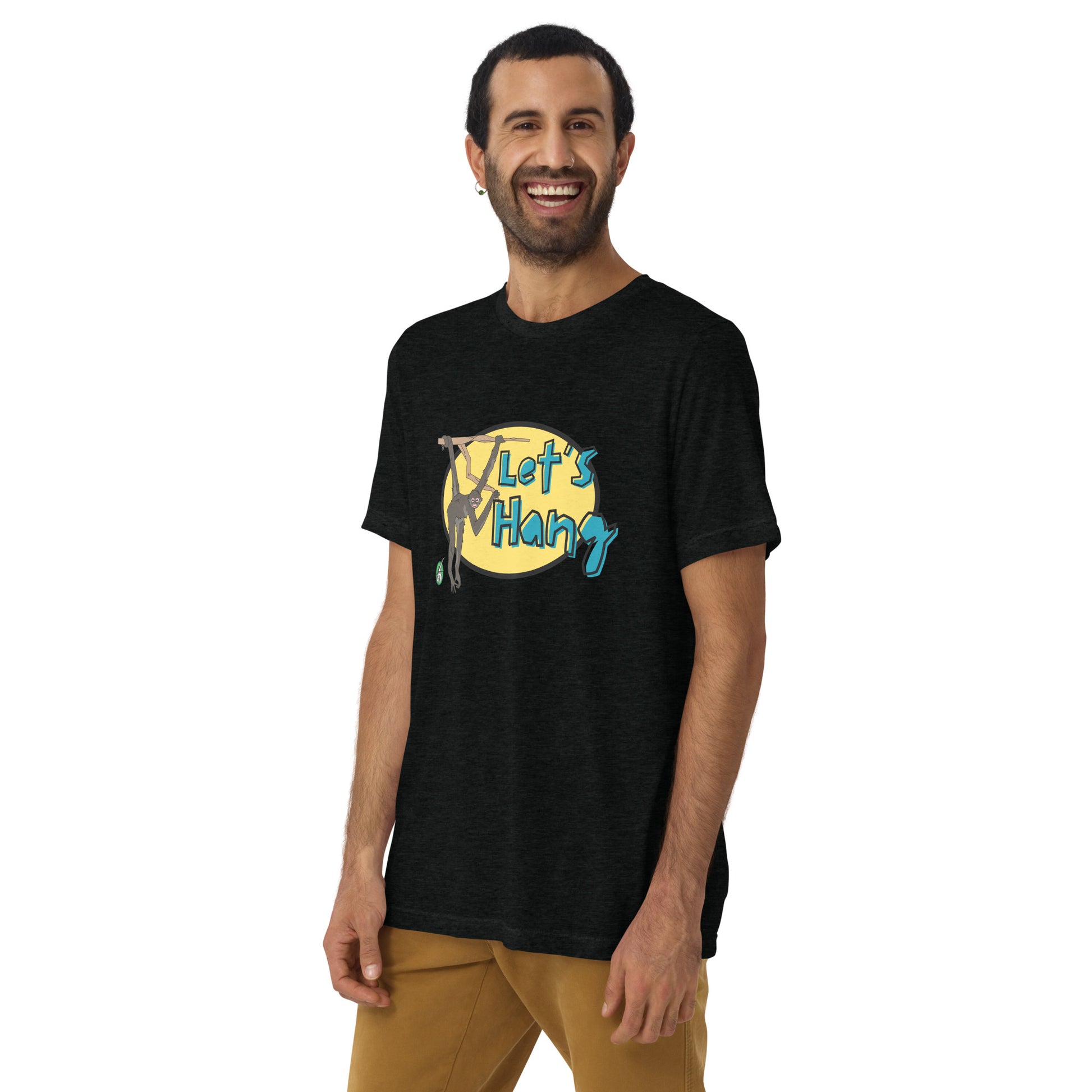 A woman standing wearing a black tee shirt with a printed graphic of a monkey hanging on a branch with the words, Let's Hang. Designed by Wizard Prints