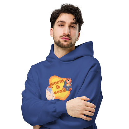 Men's blue hoodie by Wizard Prints featuring a printed graphic of a cartoon cat and bear wrapped in blankets and the words, Warm & Cozy. 