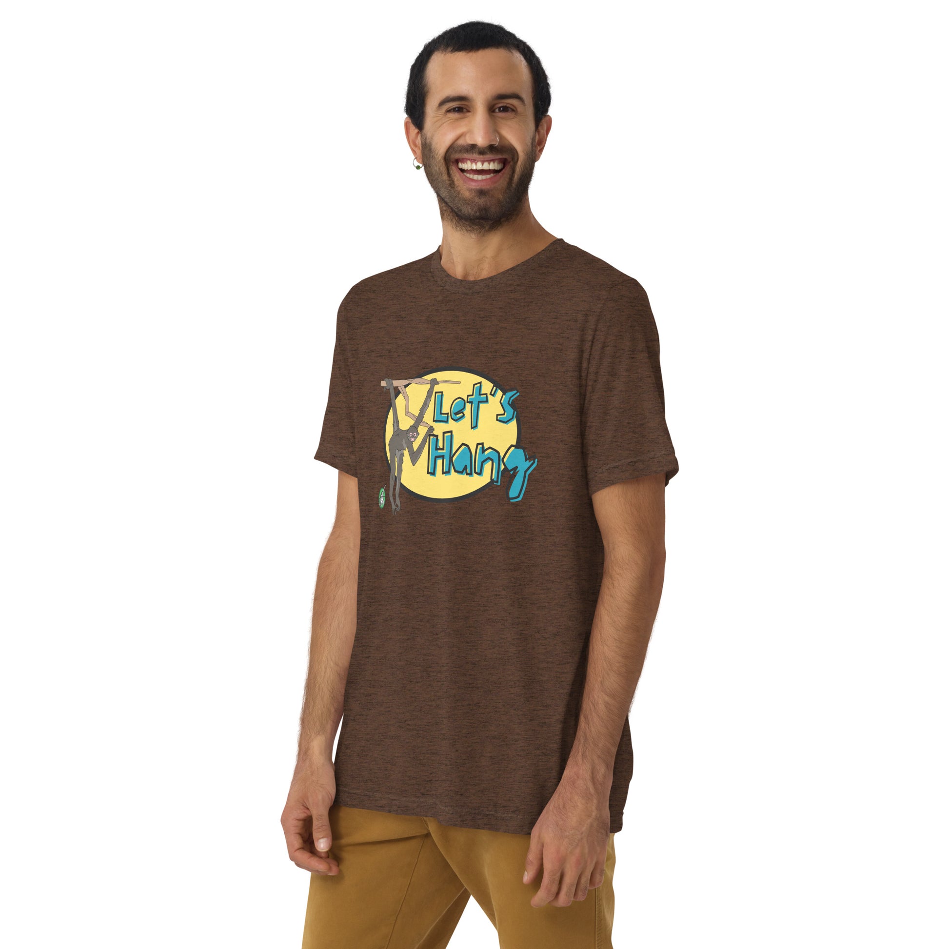 A man standing wearing a brown tee shirt with a printed graphic of a monkey hanging on a branch with the words, Let's Hang. Designed by Wizard Prints